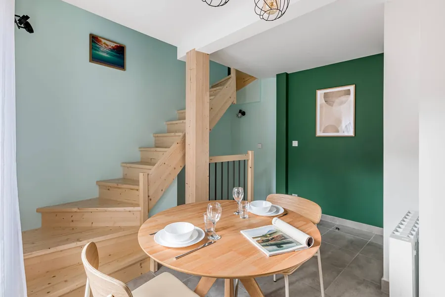 Die Treppe aus hellem Holz, die die drei Etagen verbindet